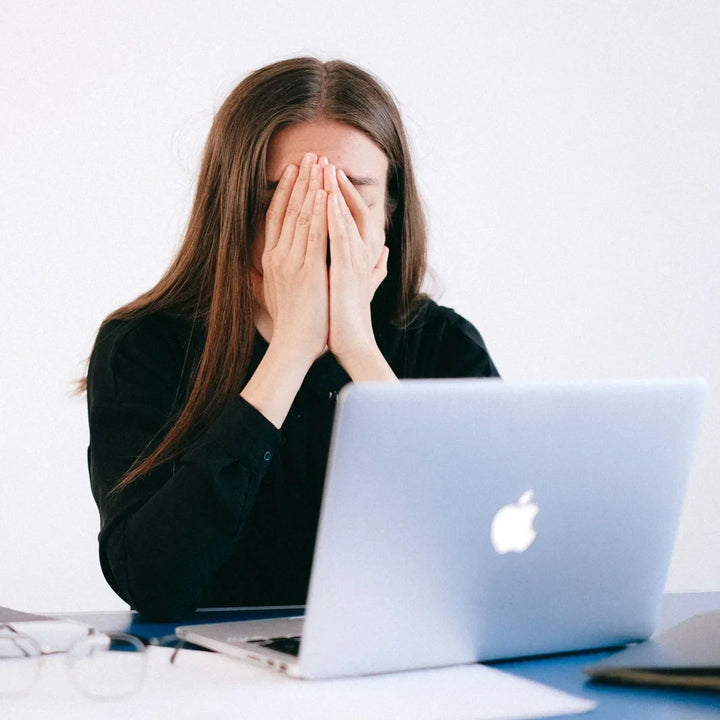 Woman experiencing mental fatigue while working on a laptop, representing brain fog and difficulty concentrating